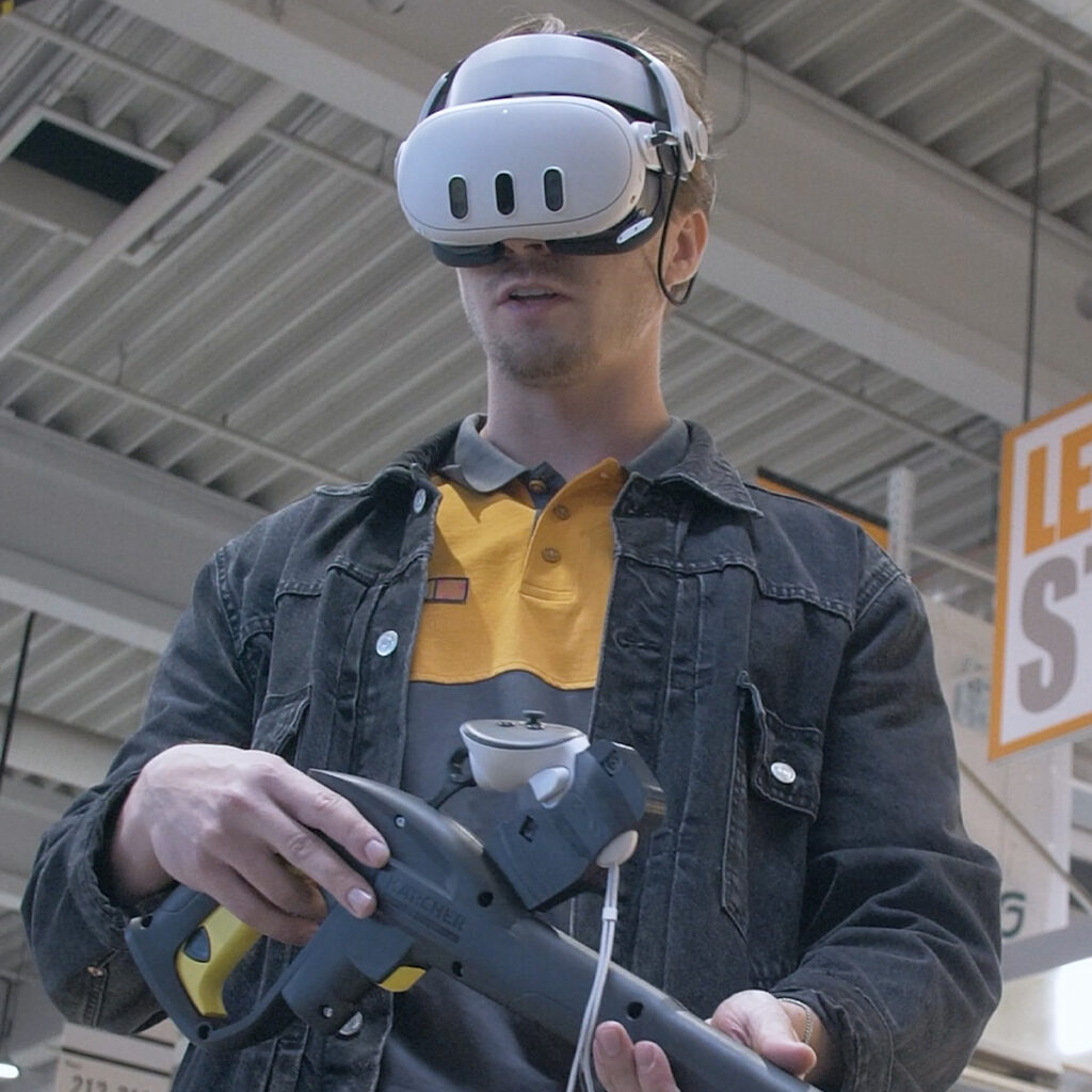 Weißer junger Mann trägt VR-Brille im Baumarkt und hält einen Kärcher | Retail AI